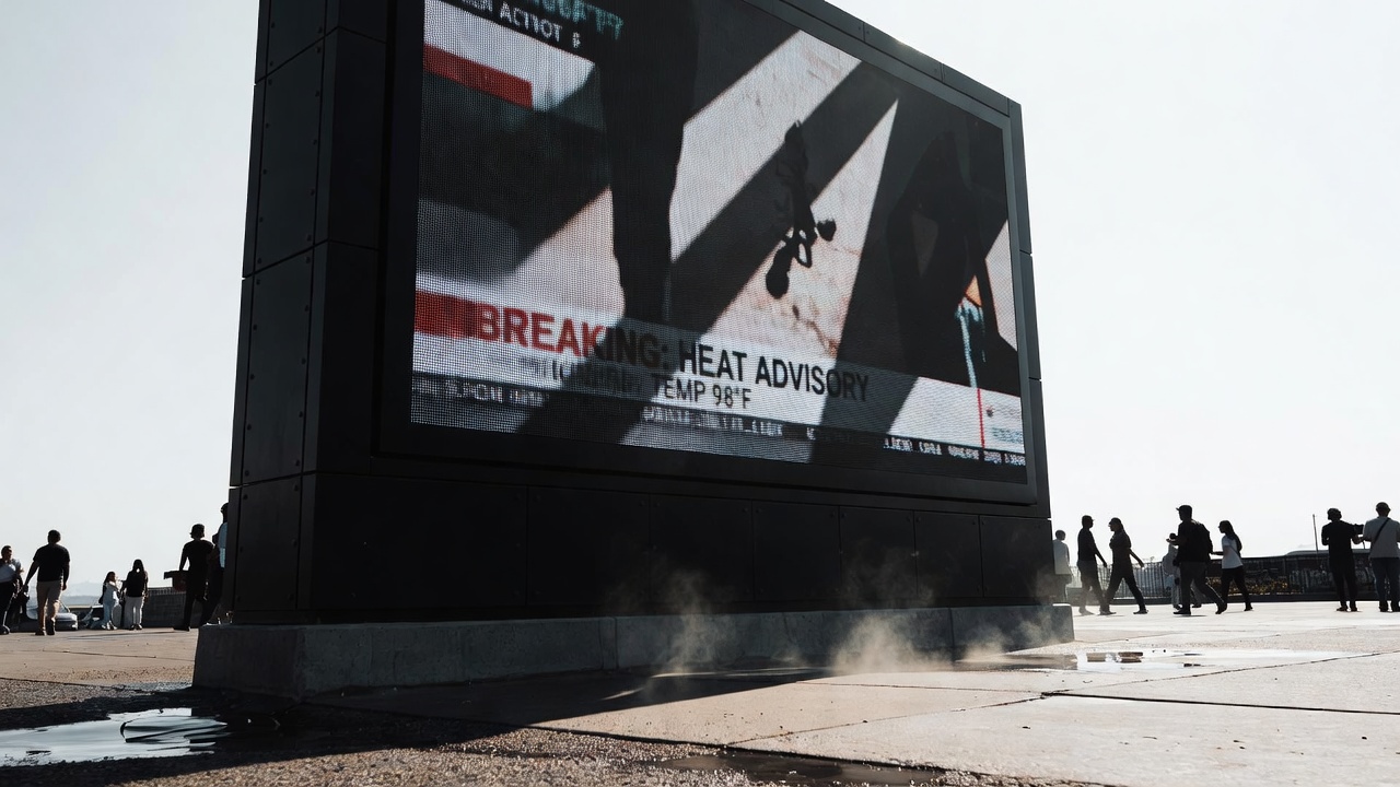 Outdoor digital display under harsh midday sunlight in an urban plaza with pedestrians silhouetted against a bright sky